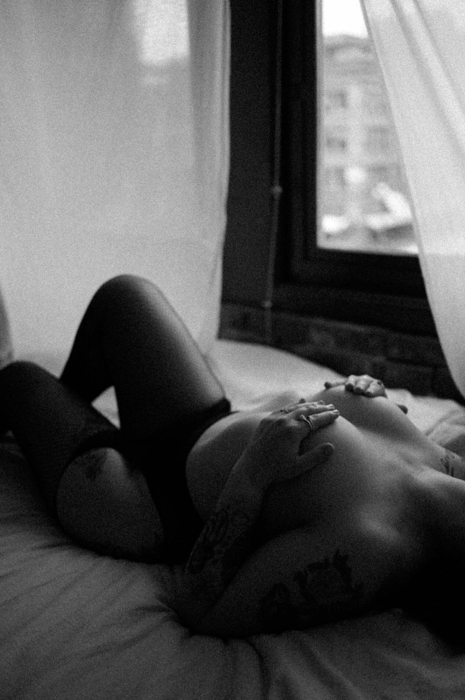 womans bare chest covered by her hands and wearing fishnet stockings