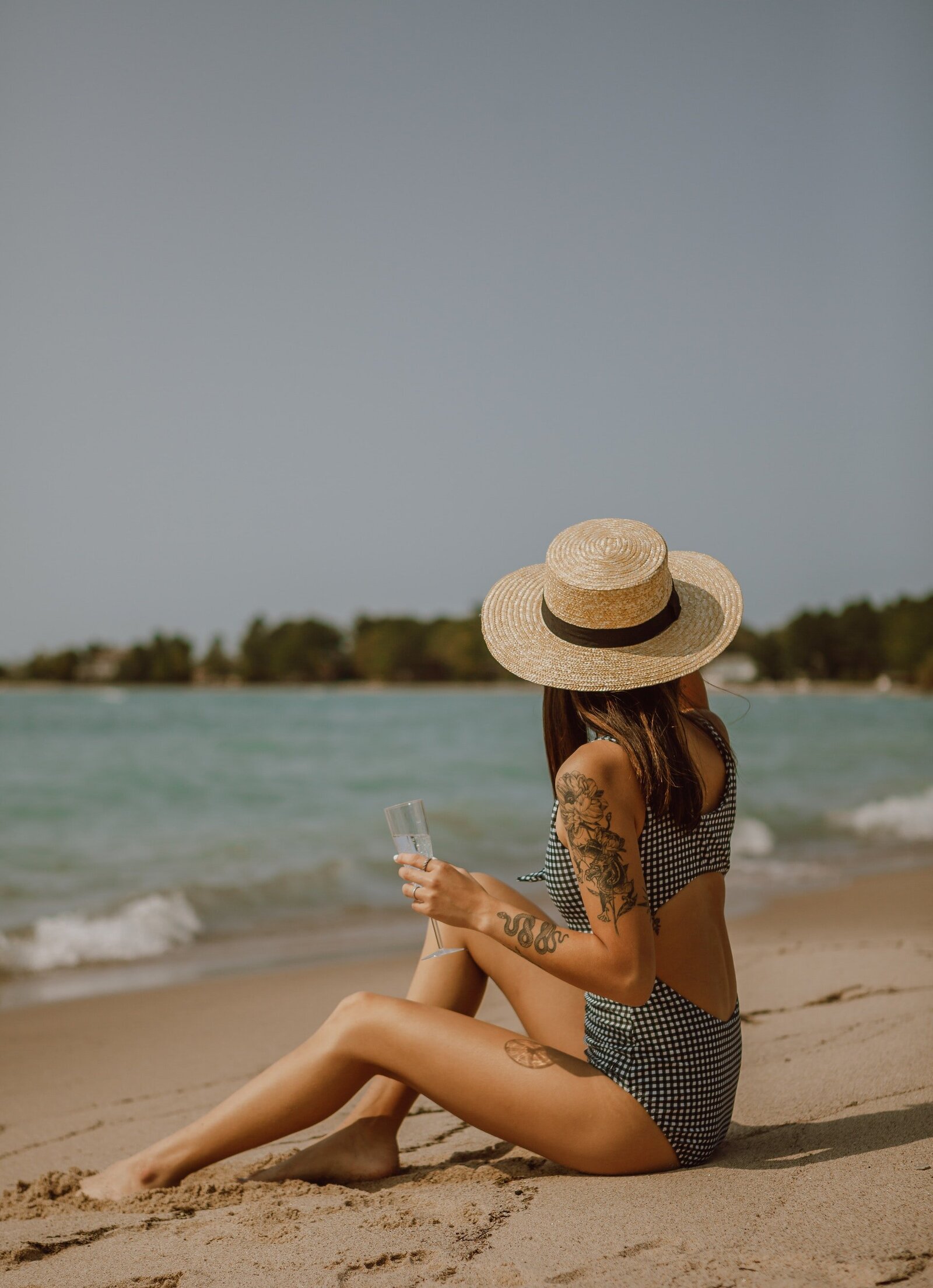 relaxed-woman-in-swimsuit-sitting-on-sandy-beach