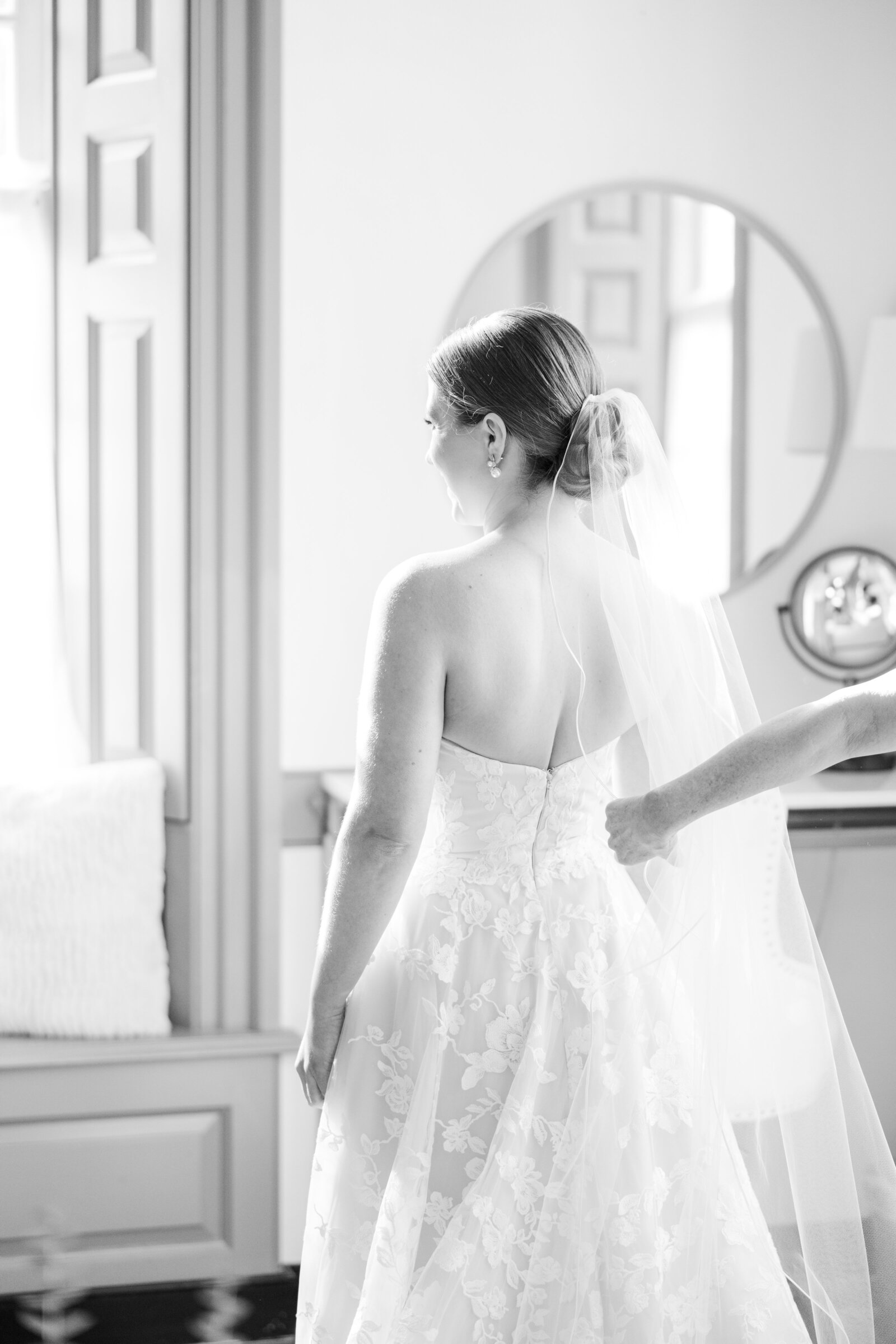 Bride getting ready for her wedding day, adjusting her veil with excitement and emotion in the bridal suite at Inola in Blue Ridge, GA