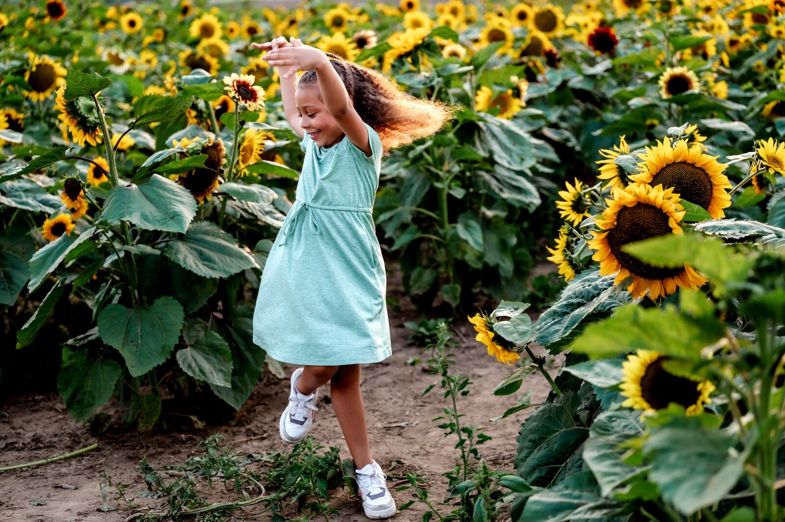 Child dancing in sunflowers