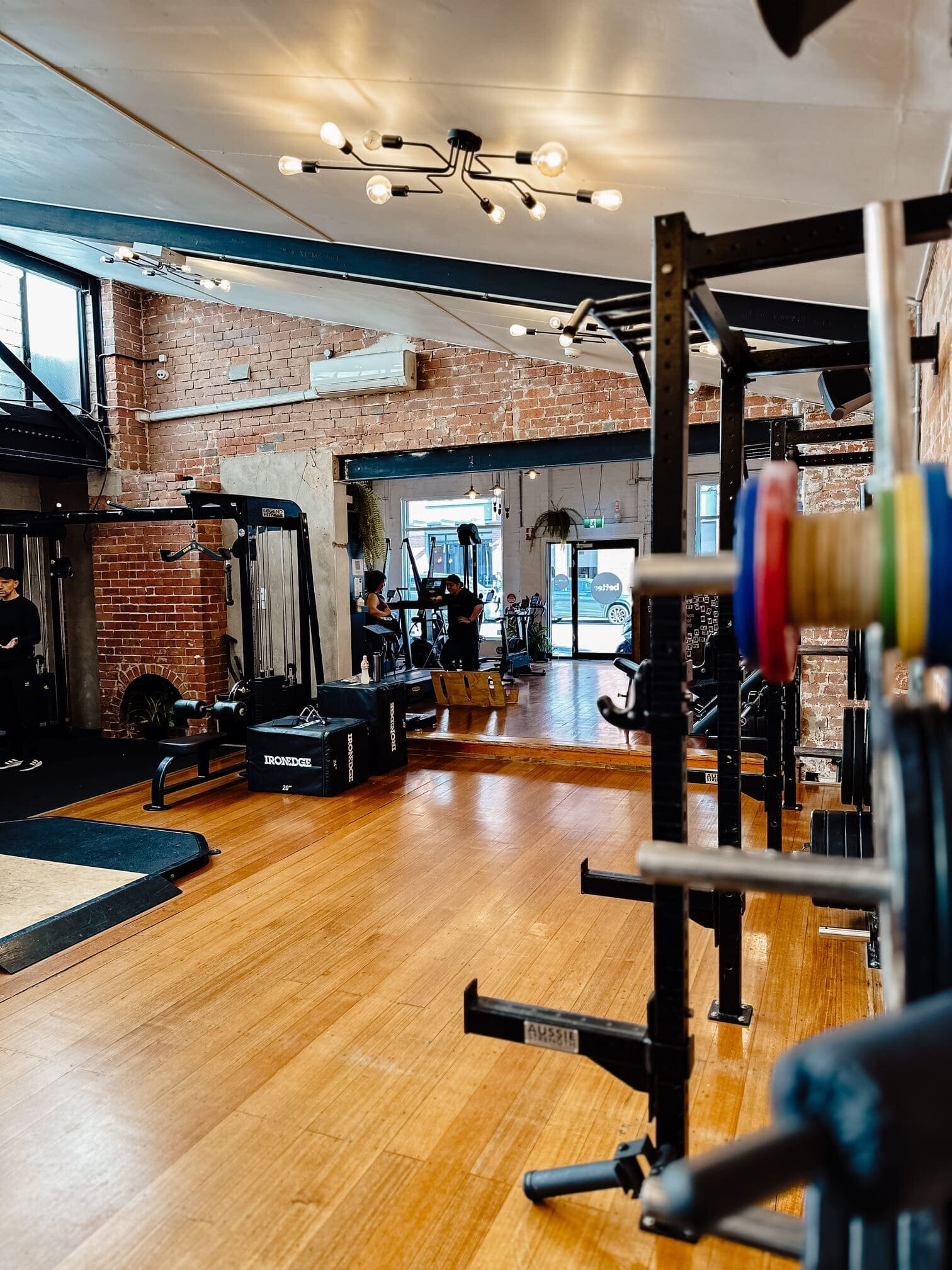Weightlifting equipment in the spacious workout area of a Collingwood gym.