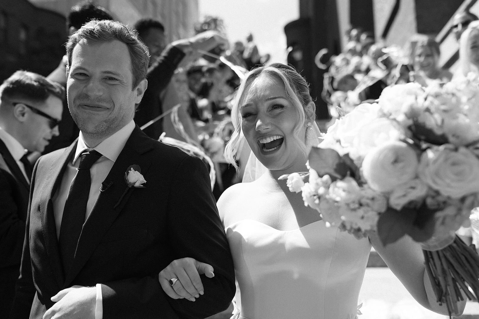 Couple leaving St Cecilia's Church in Boston while being cheered for by guests