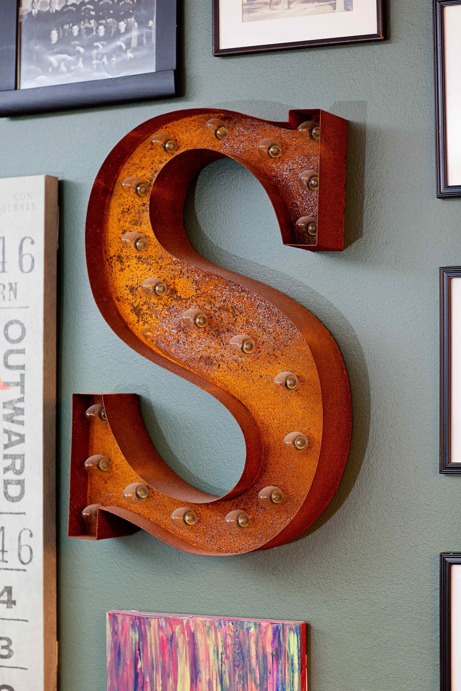 A marquee orange S in a gallery wall.