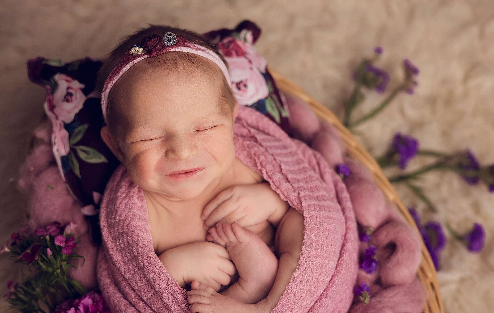 A precious newborn girl nestled in a pink blanket, expertly captured by Bia Schaefer during an in-home photography session in Orlando.