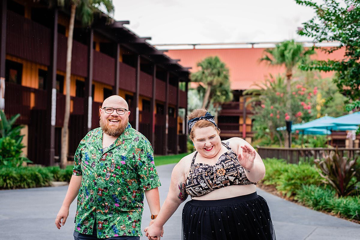 Disney influencer holding her husbands hand and walking outside the Polynesian Resort