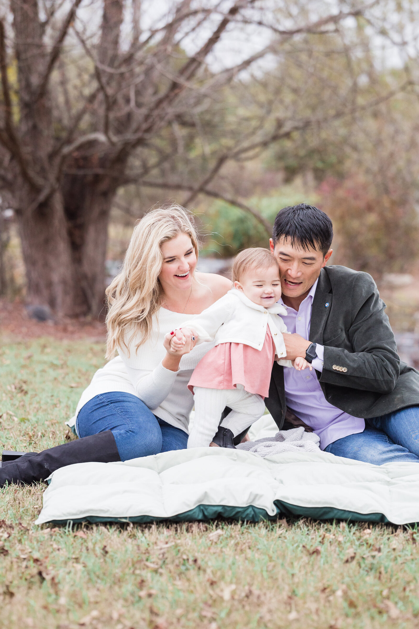 Family sitting on picnic blanket taking candid picture