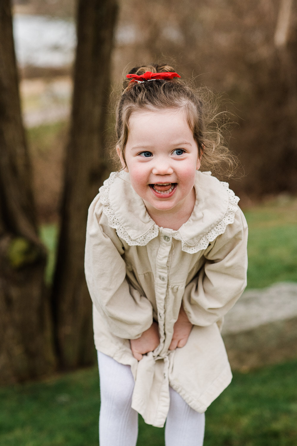 young girl laughing standing on rock