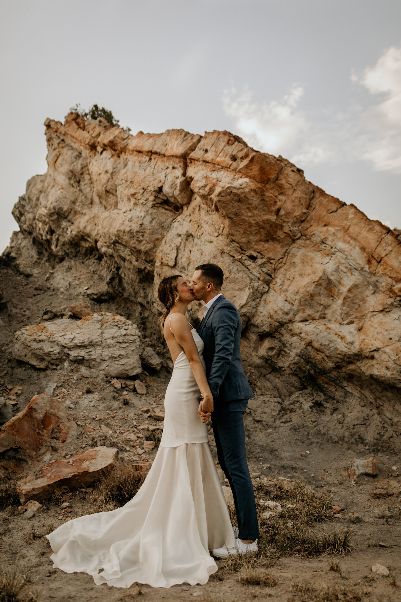 bride and groom kissing each other in the desert