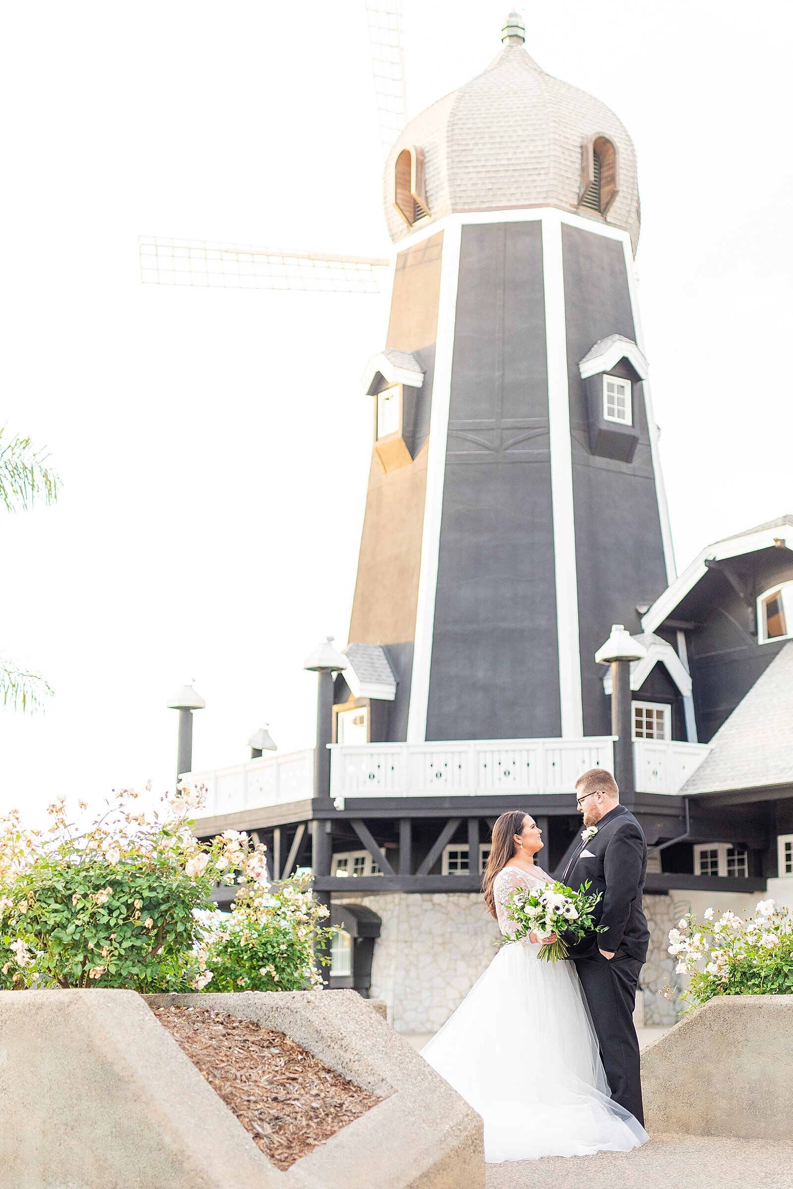 Bride and groom in front of Carlsbad Windmill Wedding Venue.