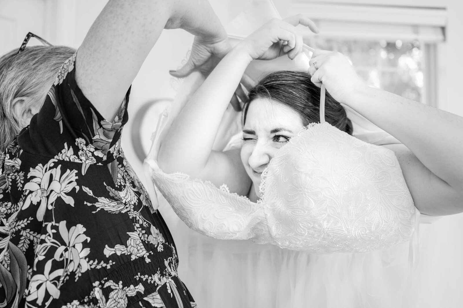 Funny moment as the bride gets her dress on before the wedding.