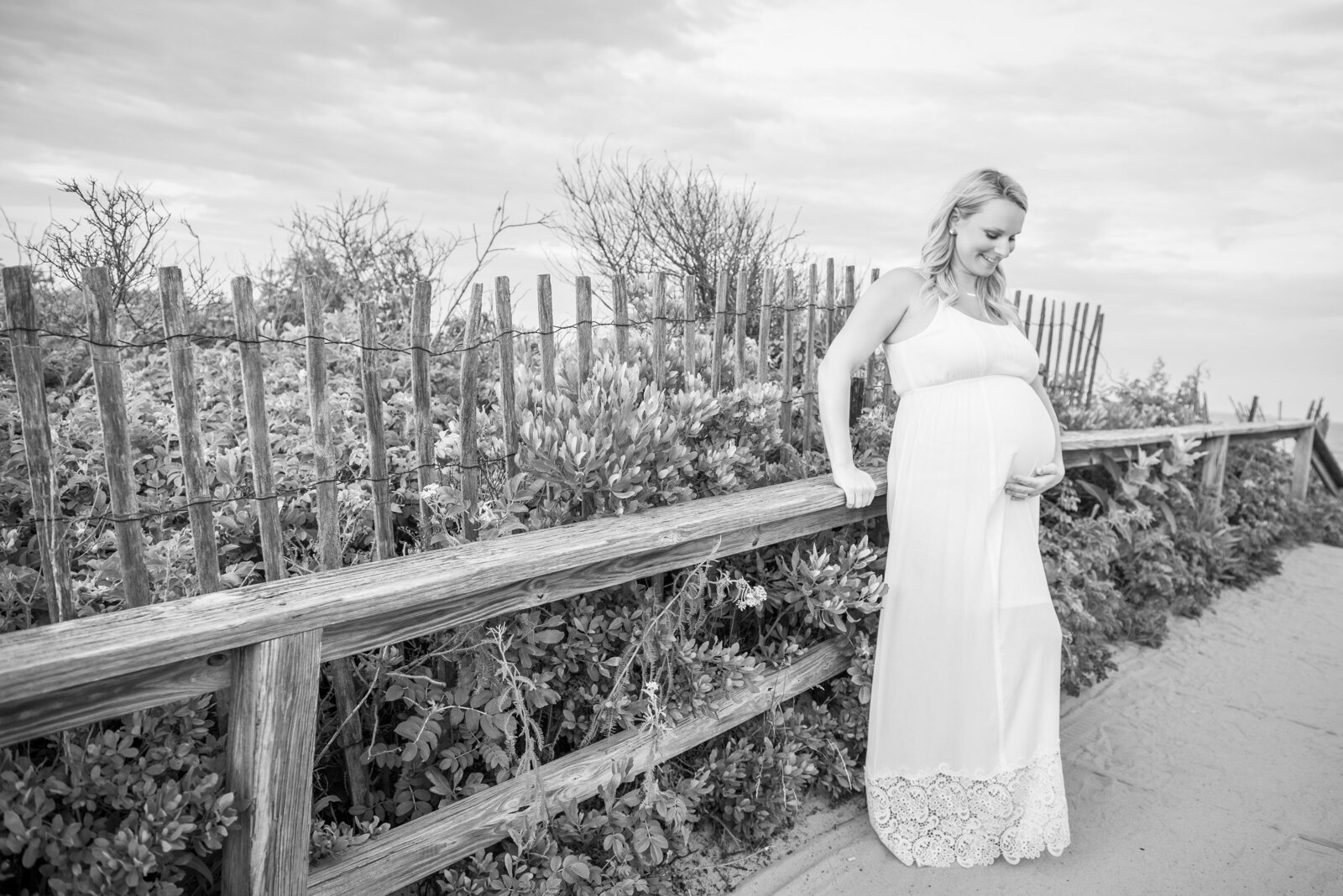 Pregnant woman posing on bridge to beach in Ogunquit Maine