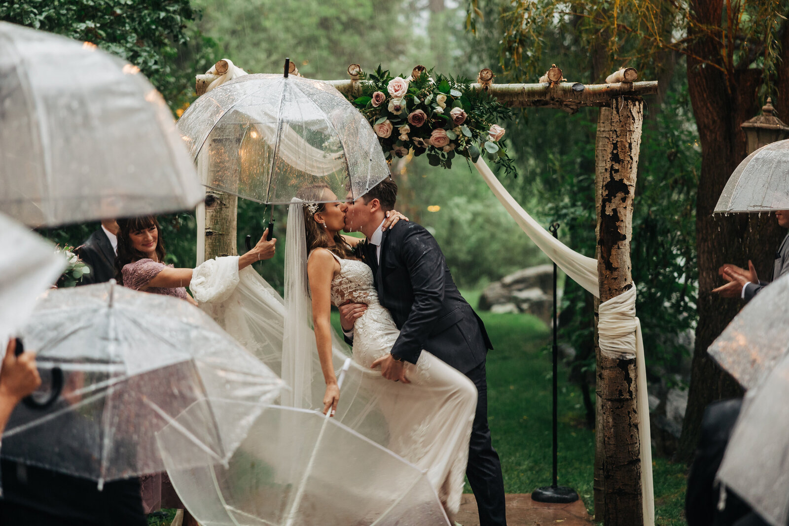 Colorado Elopement Photographer captures bride and groom kissing during rainy wedding ceremony