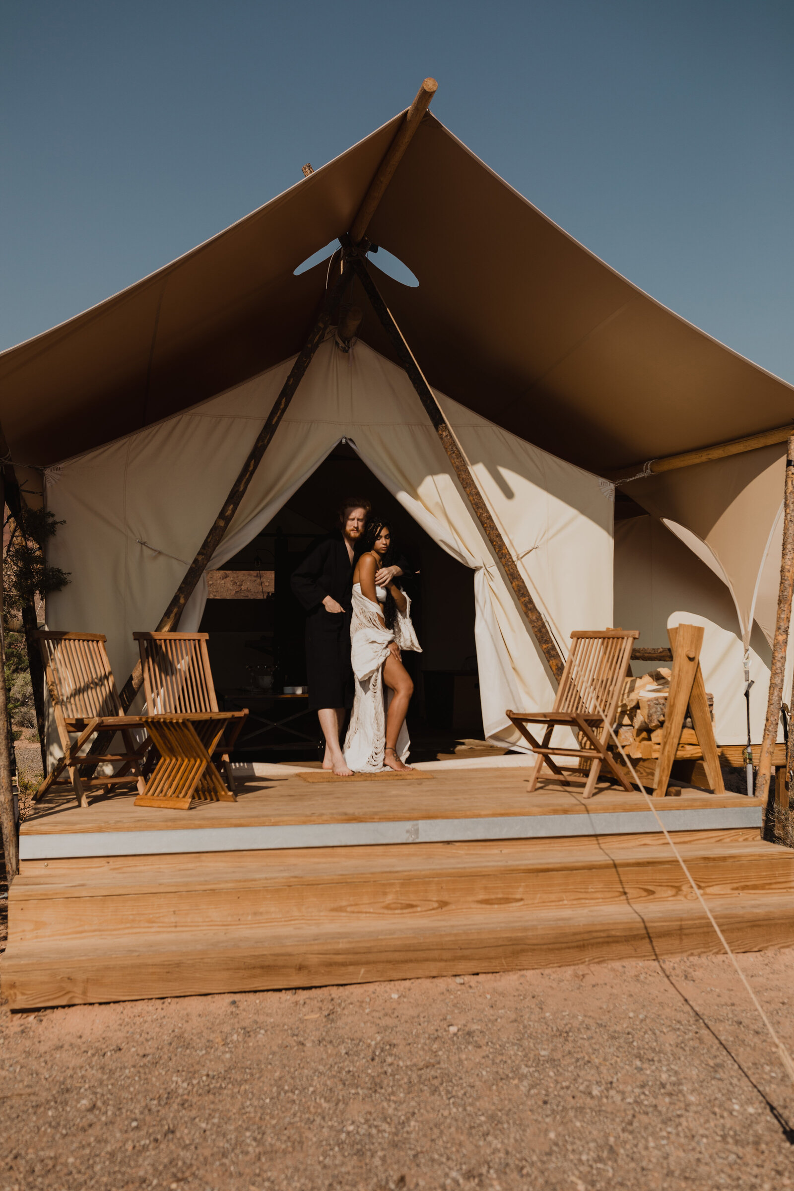 Couple stands in a glamping tent during their Moab destination elopement