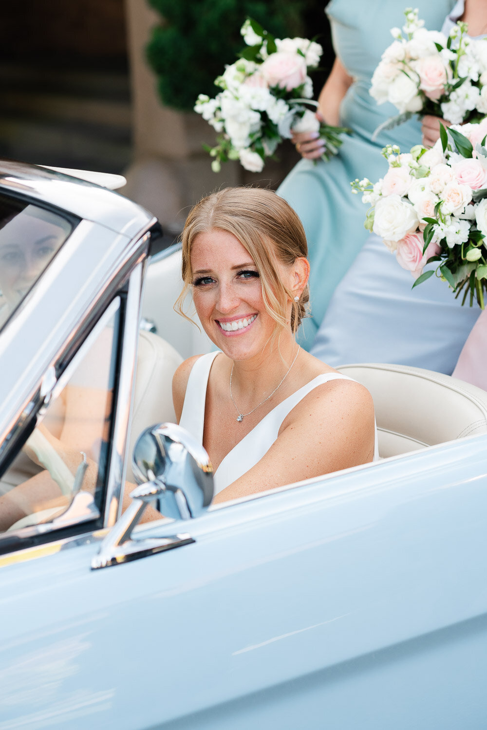 bride in blue classic car smiling