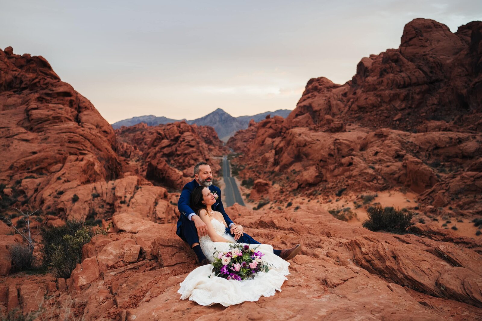 Newlywed sitting on a rock at Valley of Fire during their wedding in Las Vegas.