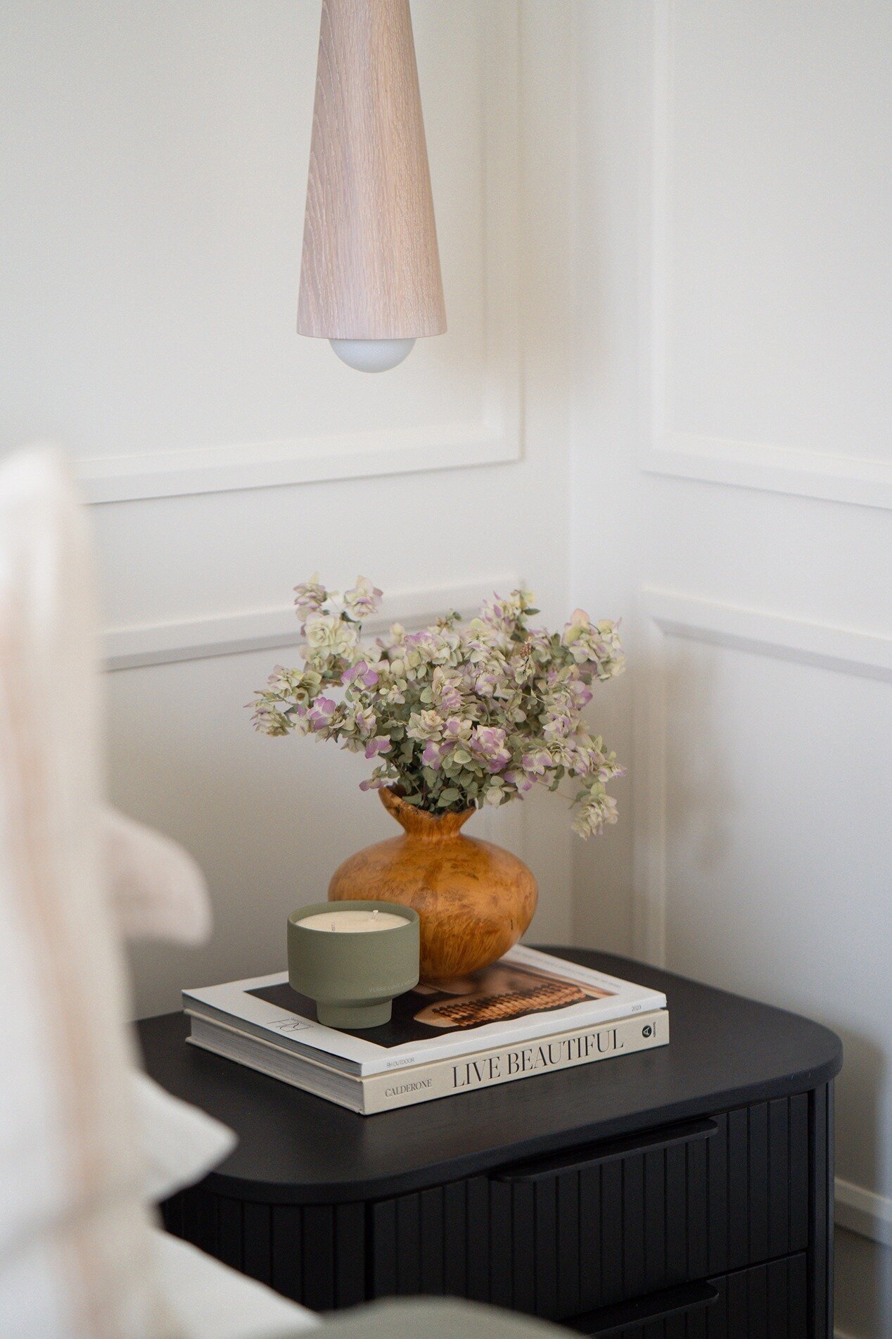 Vase and candle on coffee books in bedroom
