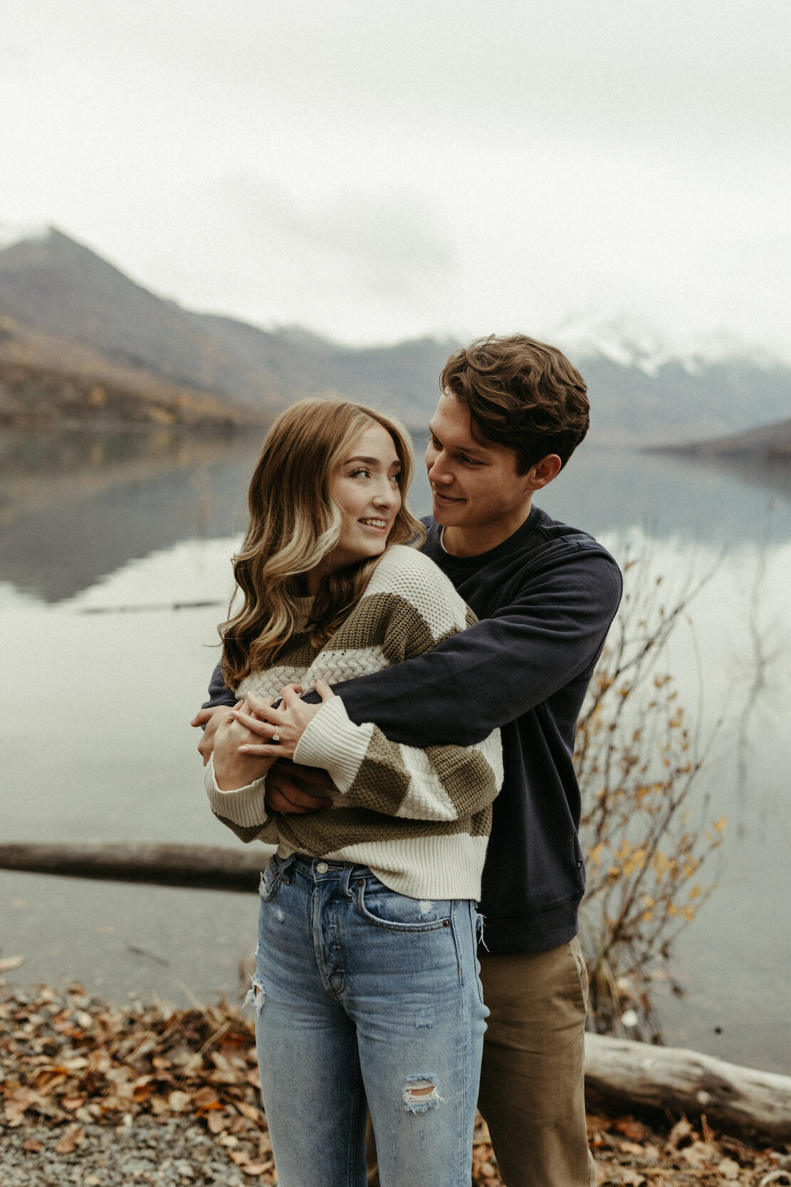 Man holding a woman next to a lake