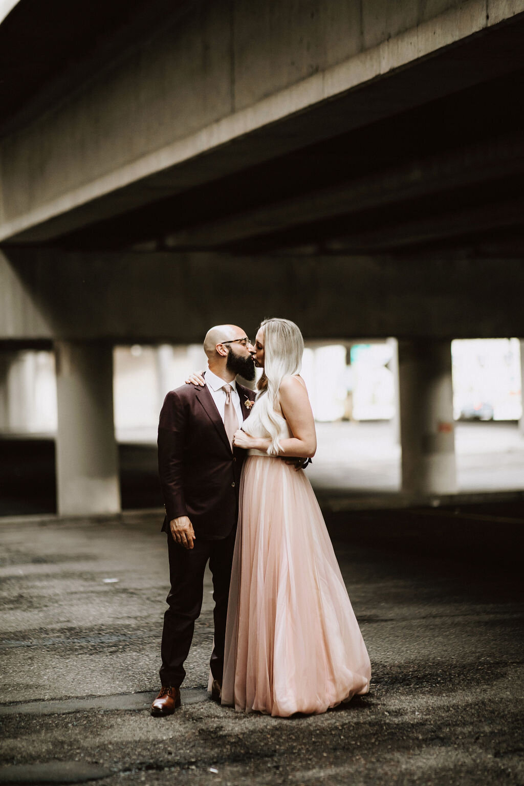 bride-groom-portrait-parking-garage-blush-dress-kiss