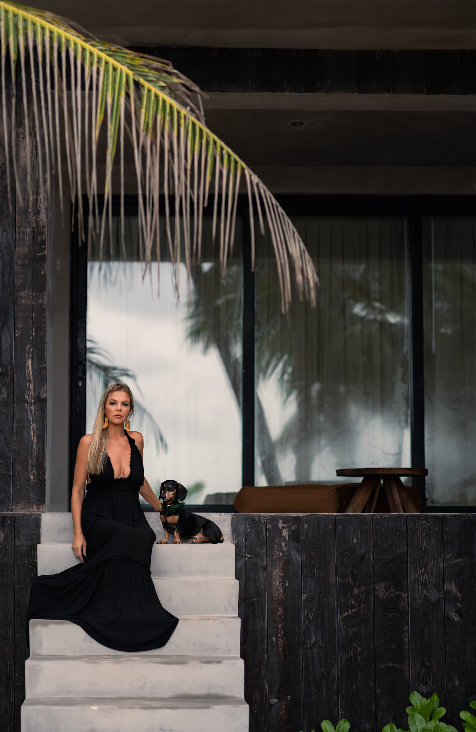 jungle luxe rachel wearing black dress with mason dog