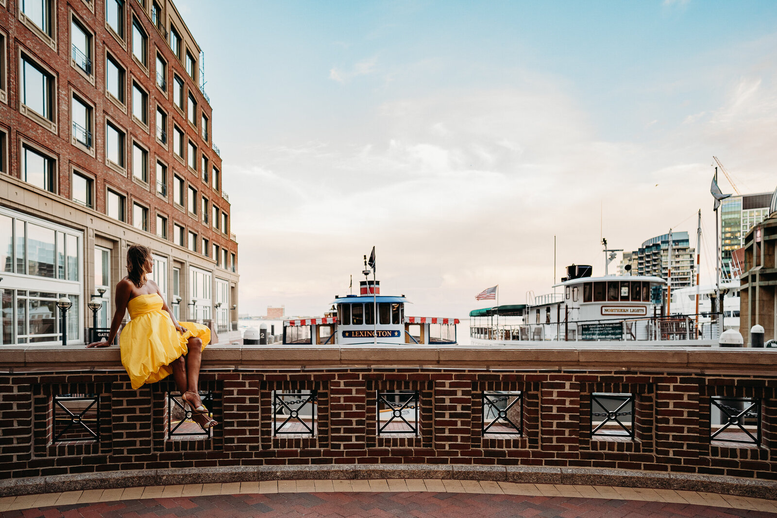 woman sits on wall in Boston Seaport district