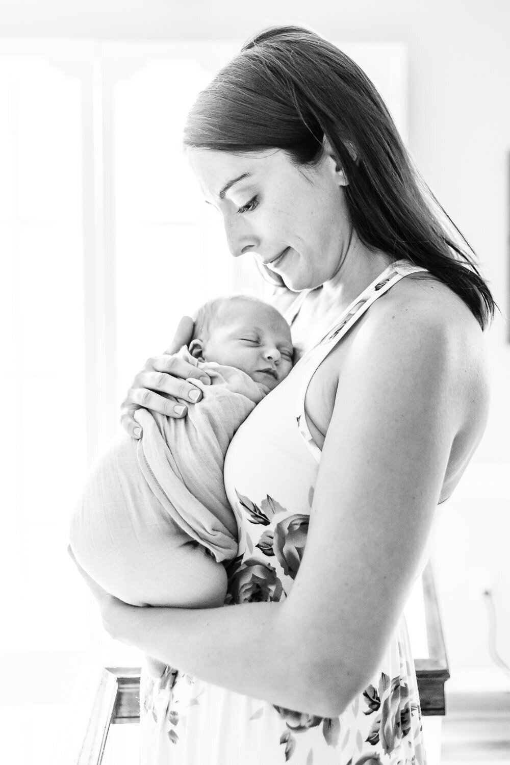 Beautiful black and white photo of mother holding sleeping newborn baby