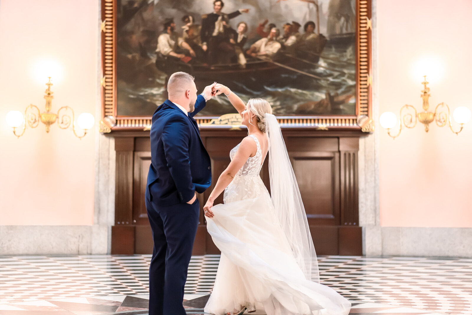 Bride and groom, Rachel and Jeff, dancing in front of a painting at the Ohio State House in Columbus.