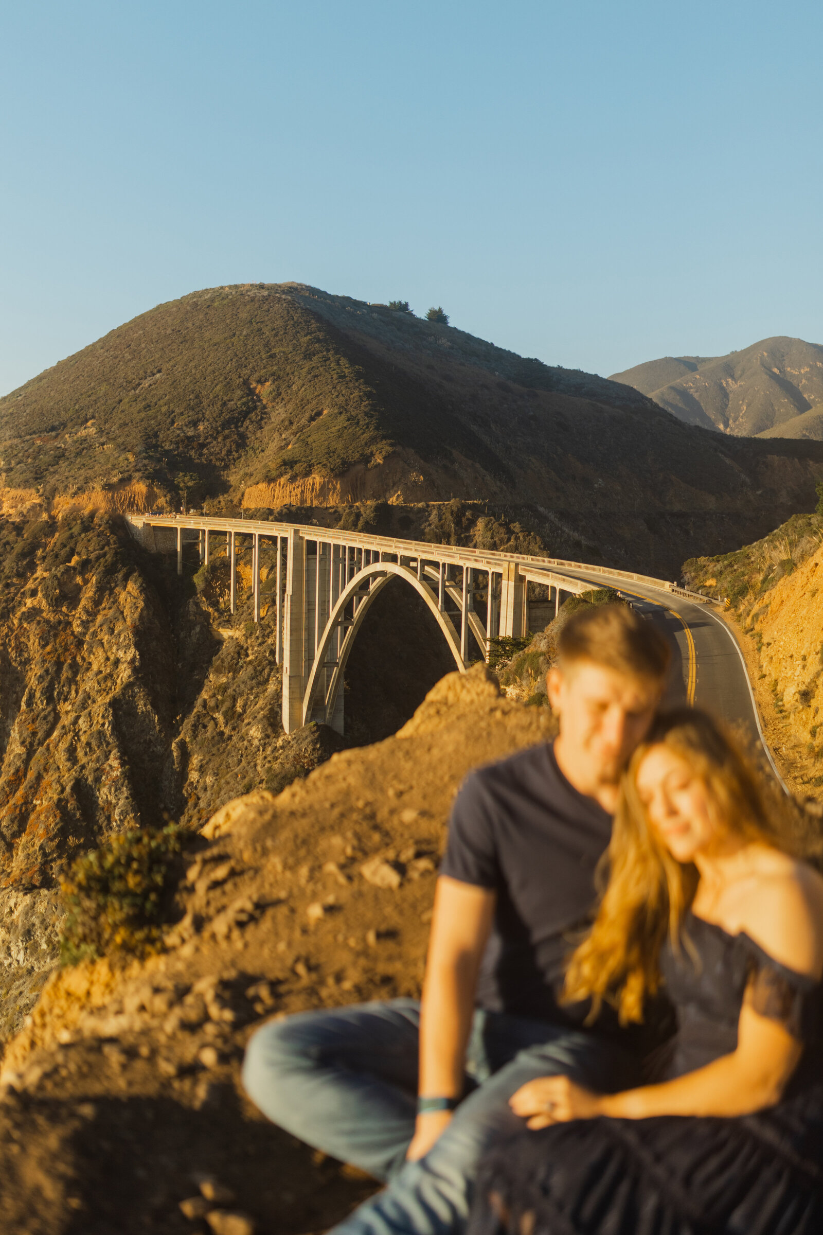 A couple poses for their engagement photos in Big Sur, California.