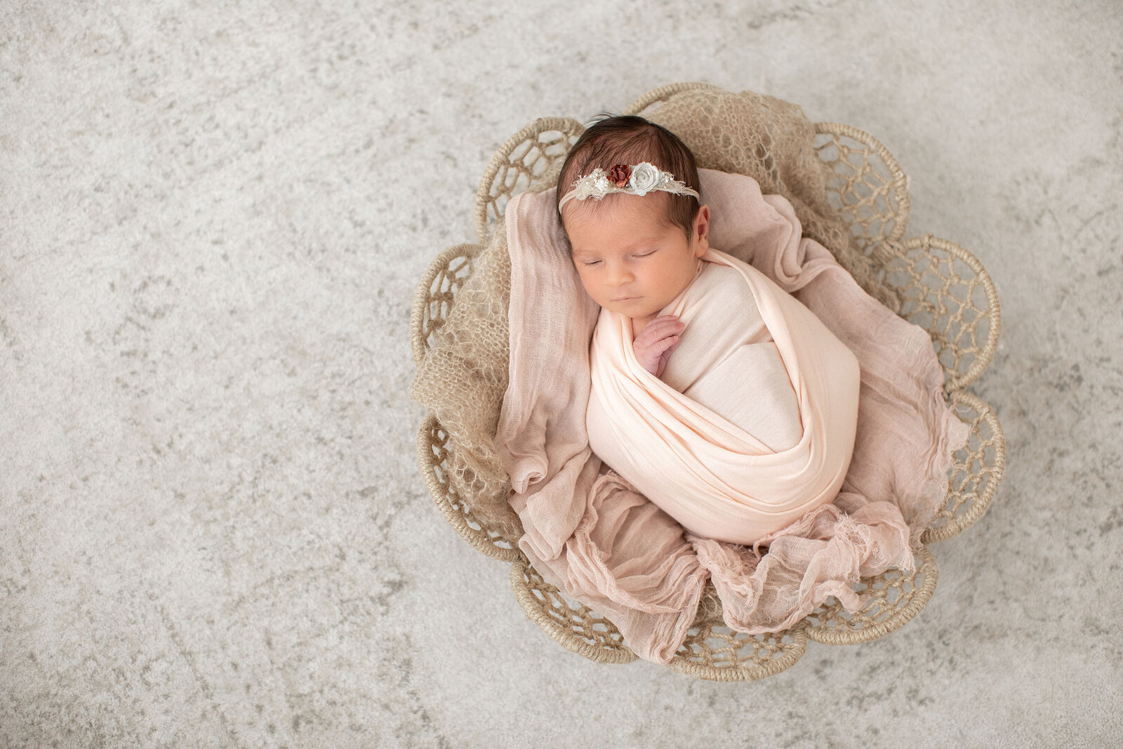 a swaddled newborn baby girl in a basket during her Bucks County newborn Photographer session at Ivory Tree