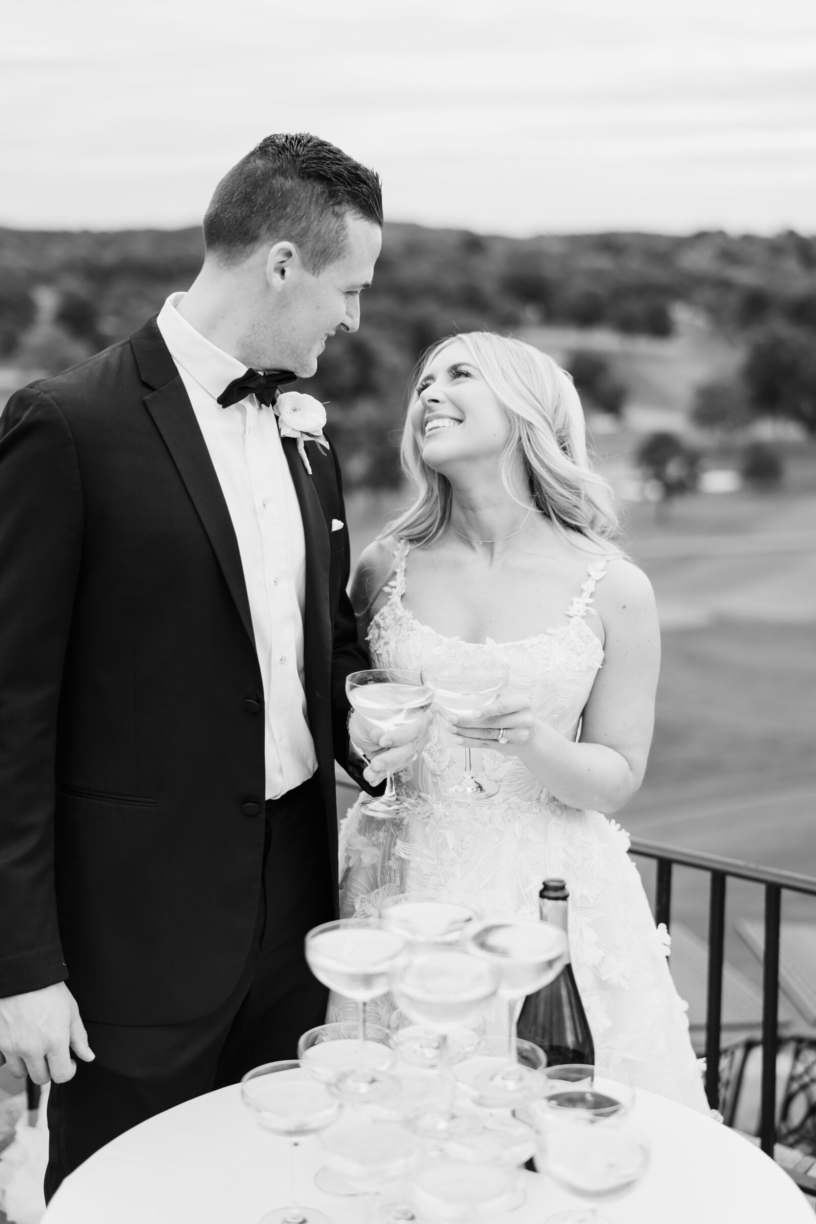 Bride and groom share glasses of champagne while overlooking a golf course