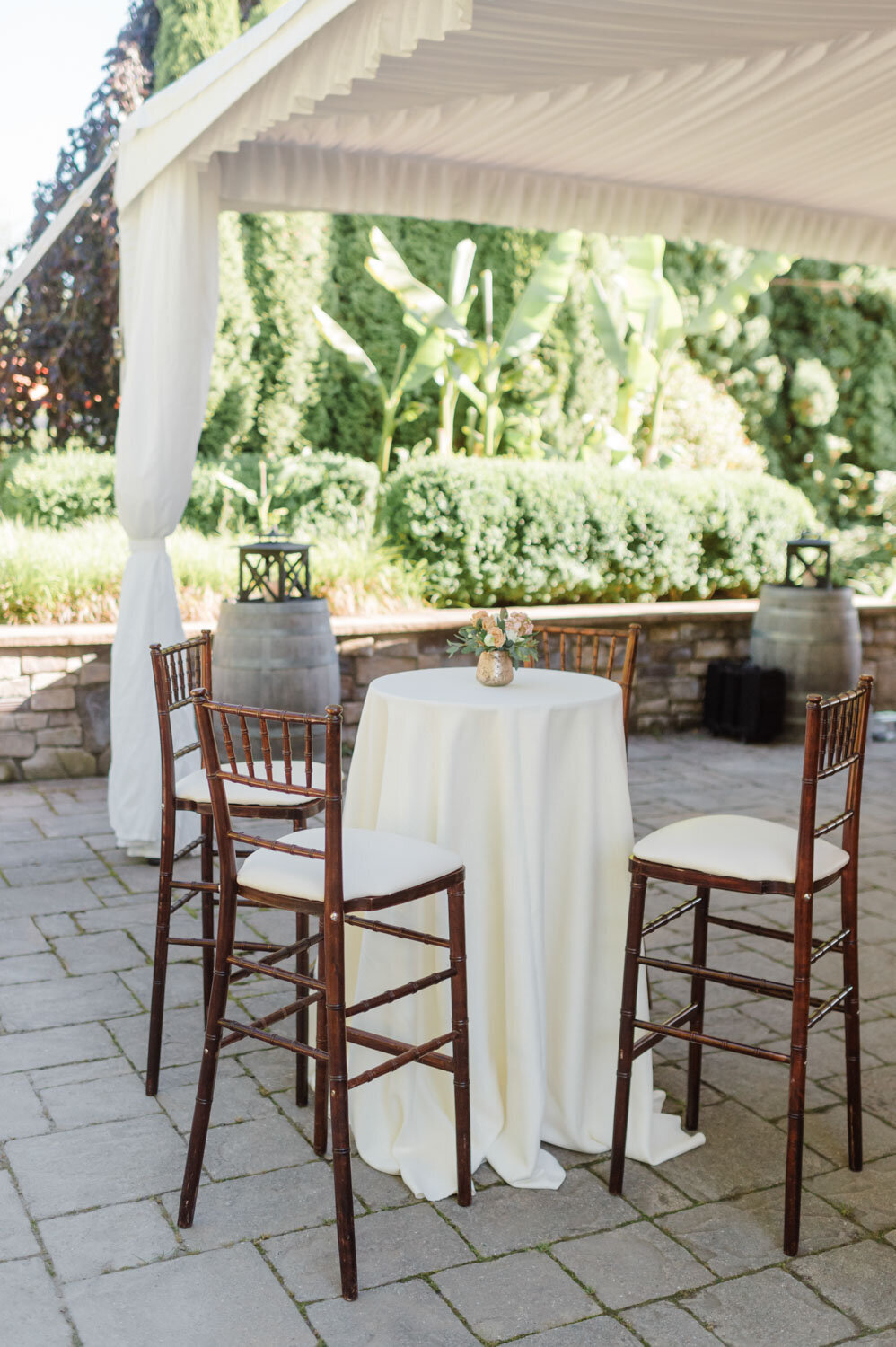 Outdoor cocktail table setup under a tent