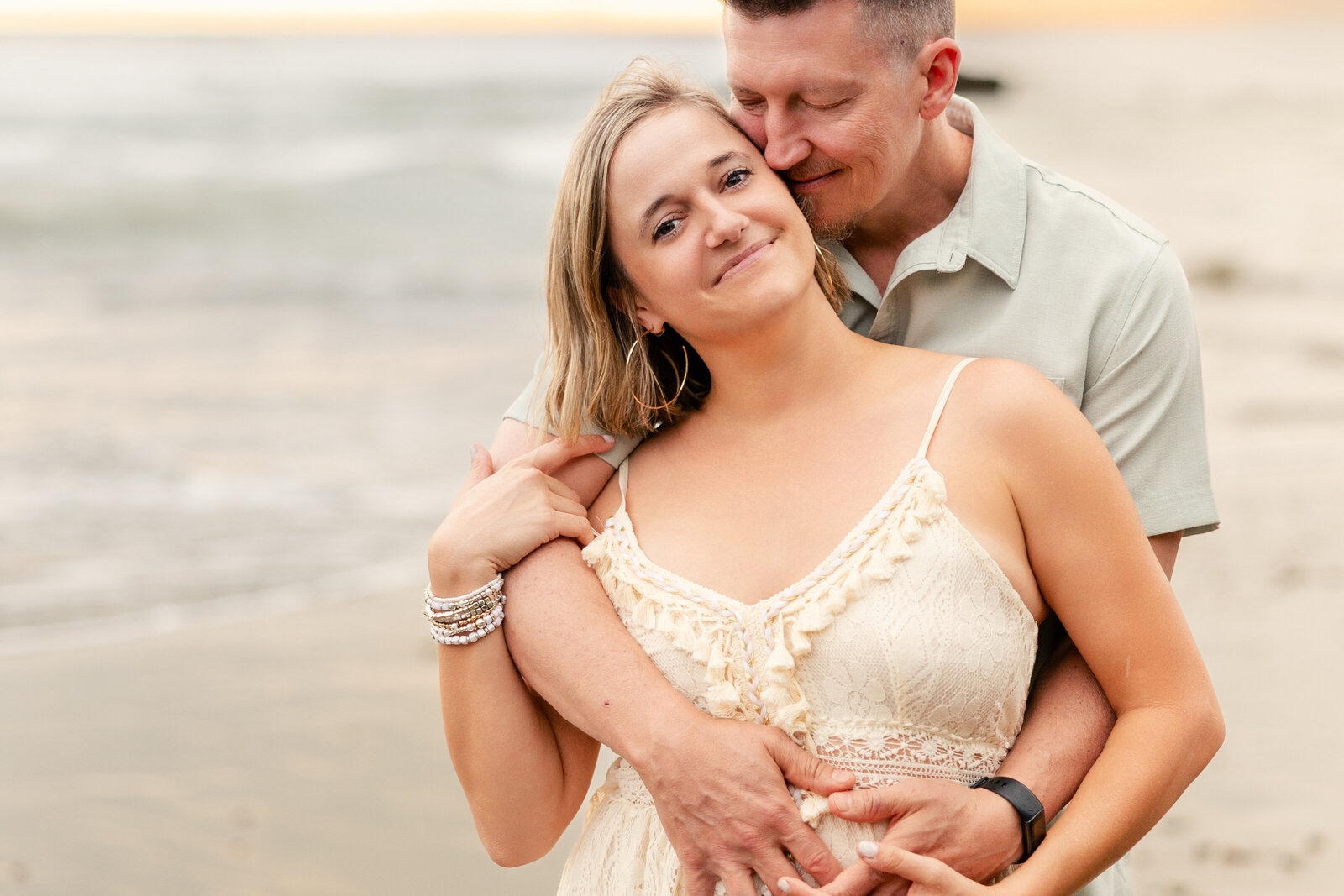 woman looking at camera as man snuggles into her hair
