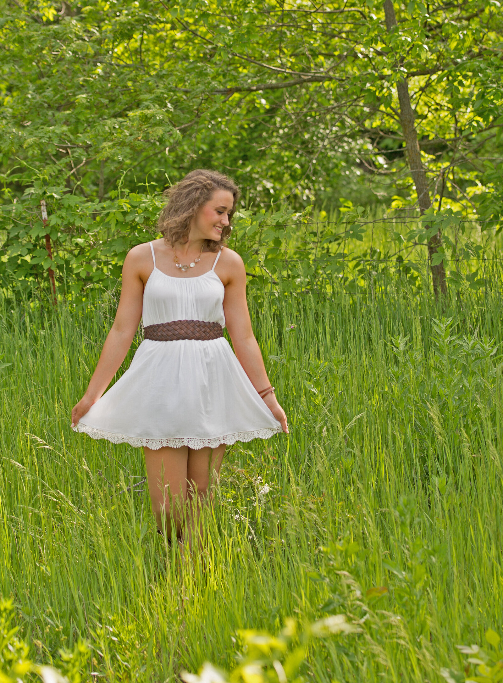 Payten poses a white dress  in a green field