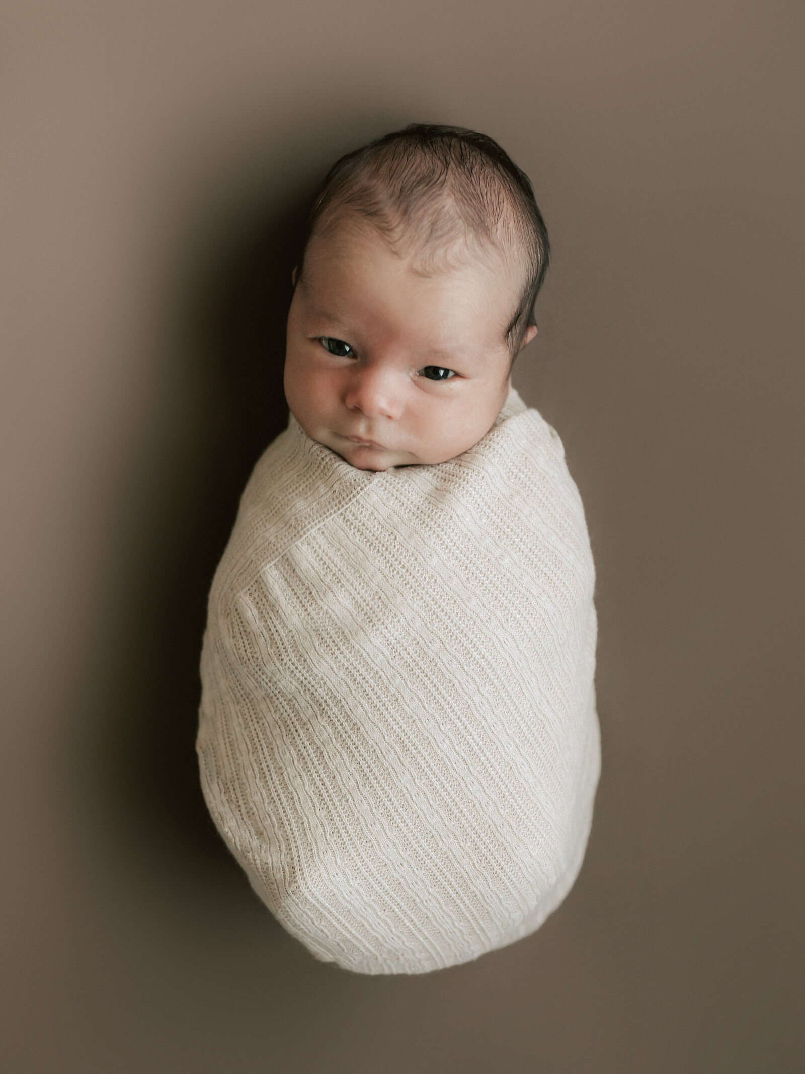 baby boy wrapped in beige for in home lifestyle session