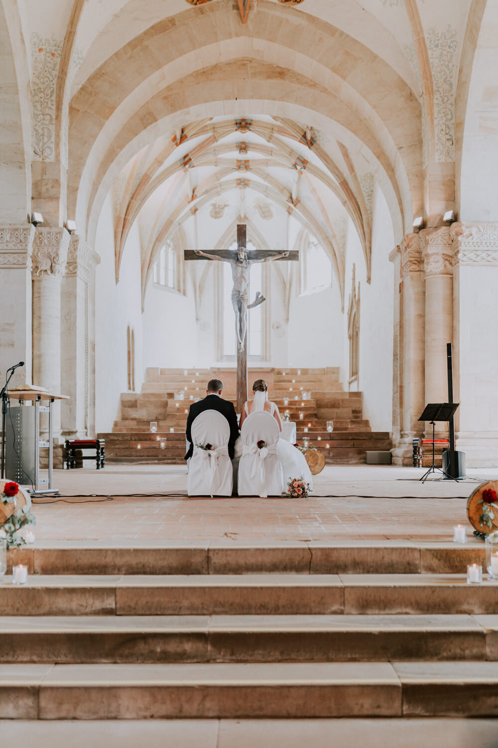 Brautpaar sitzt mit dem Rücken zu den Gästen während der kirchlichen Trauung Kloster Lorch