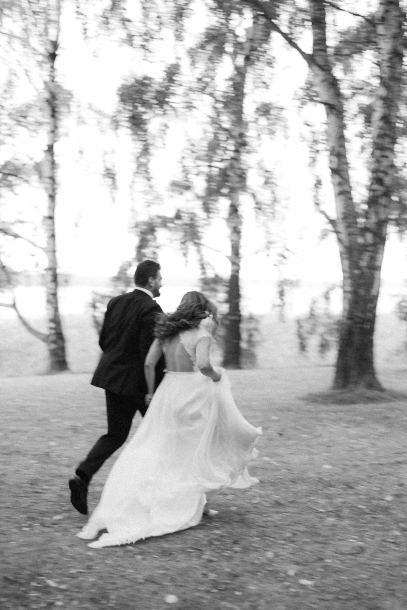 The wedding couple is running in a wedding photo by Finnish wedding photographer Hannika Gabrielsson.
