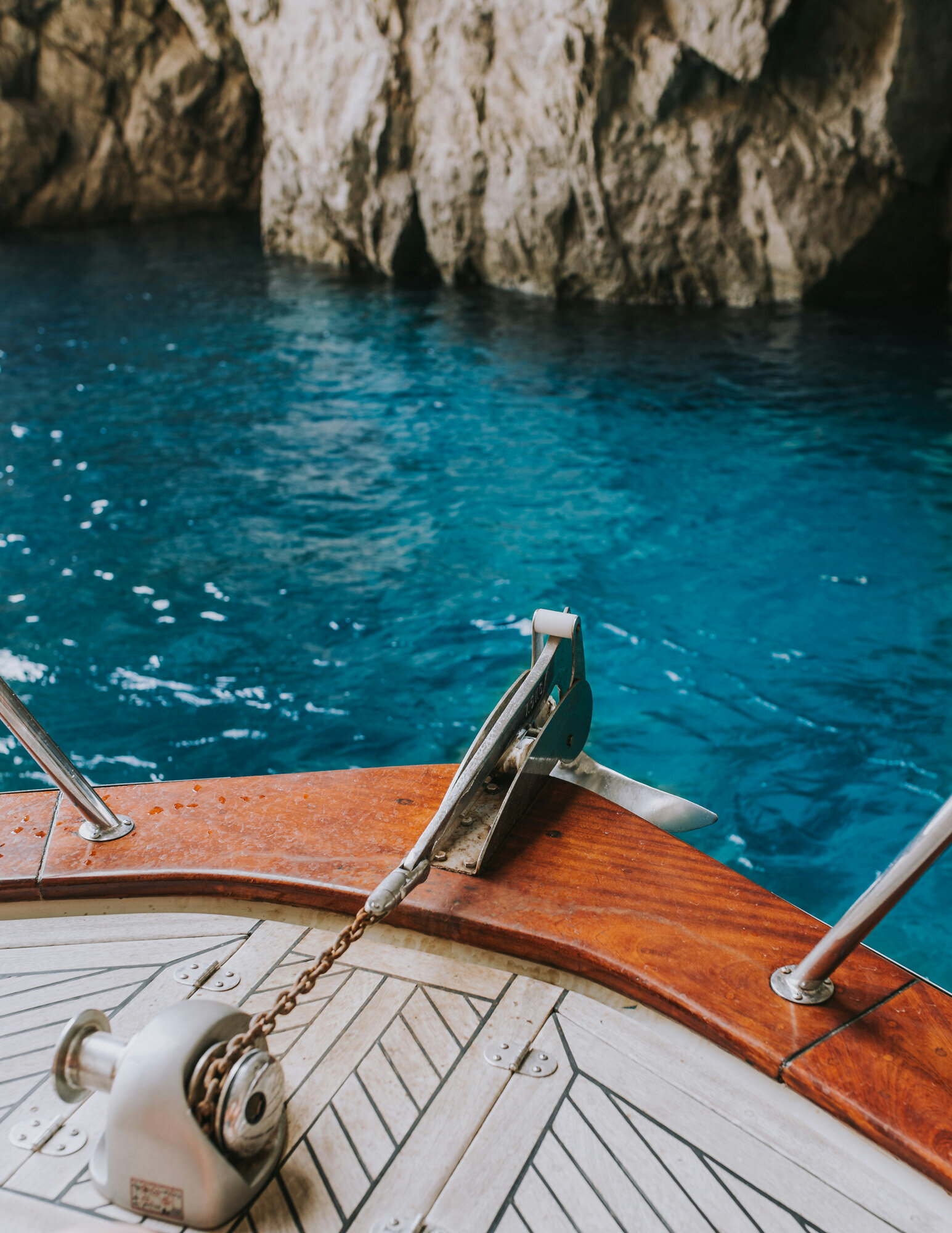 close-up view of a boat's deck featuring a sturdy anchor on wooden planks
