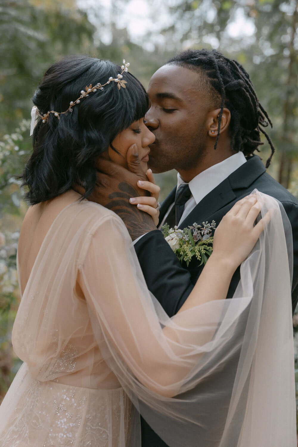 Groom kissing her bride on cheeks