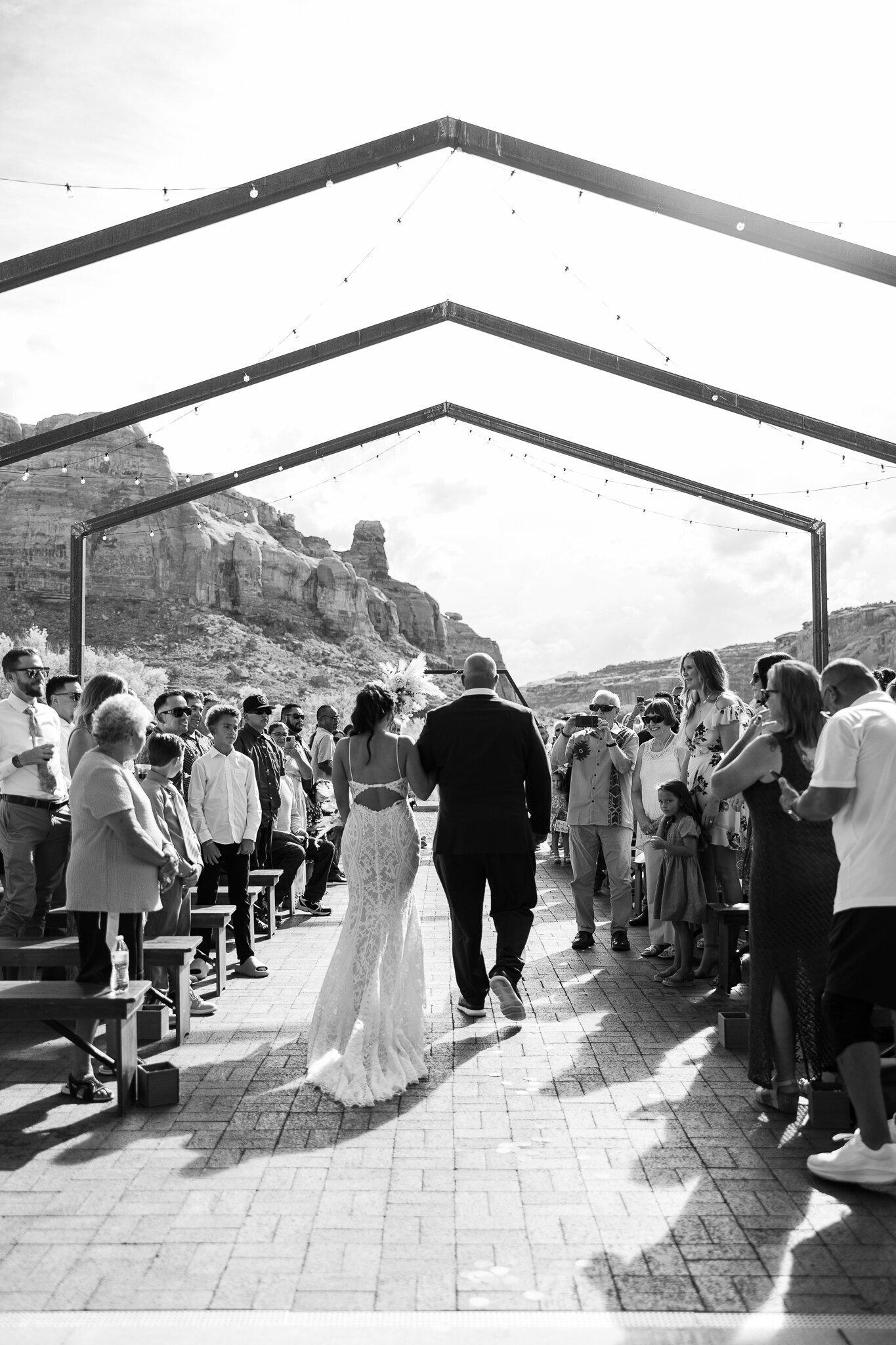 black and white of father walking bride down the aisle to giver her away