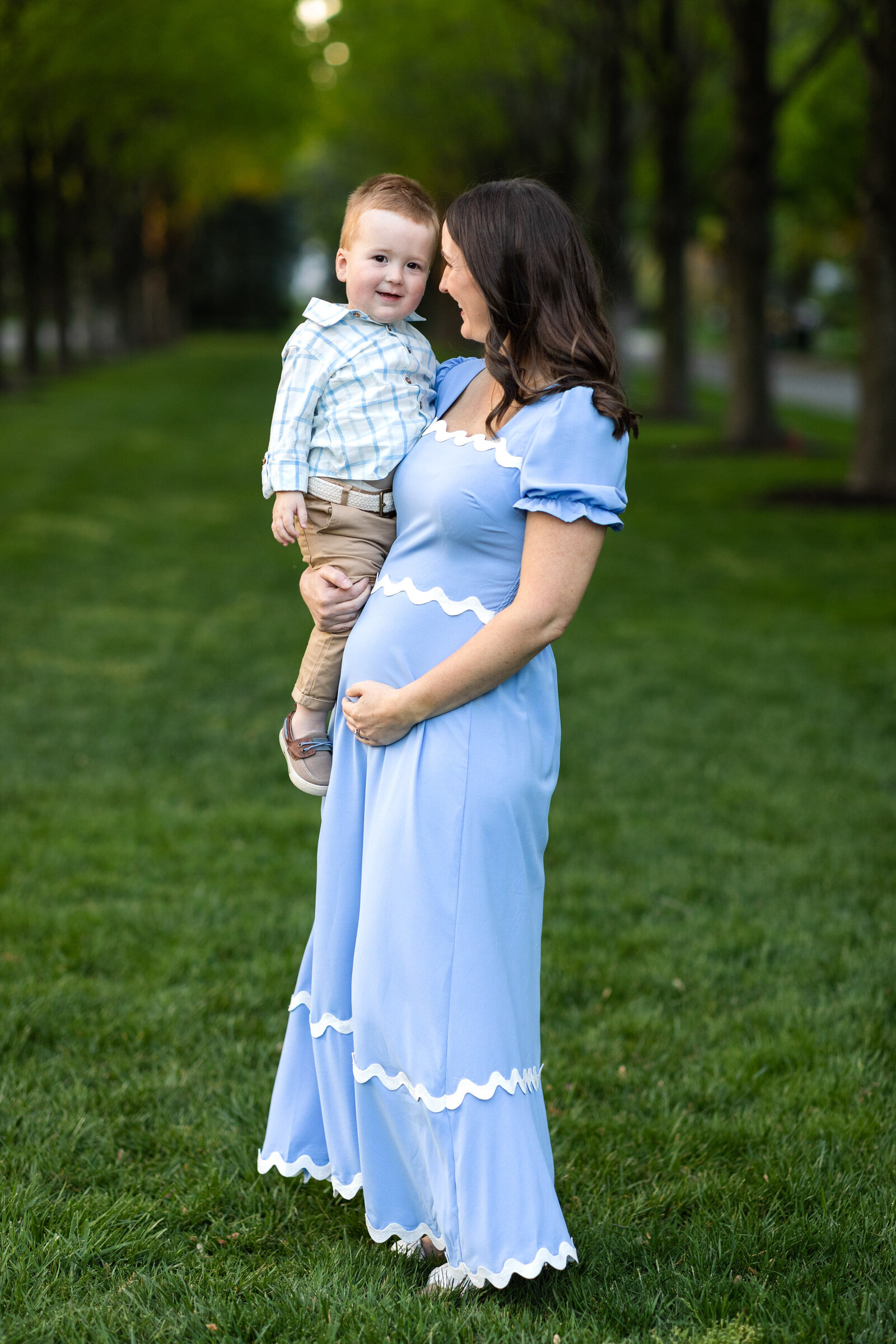 Kansas_City_Maternity_Photographer_blue_dress_with_toddler_on_lawn_with_trees