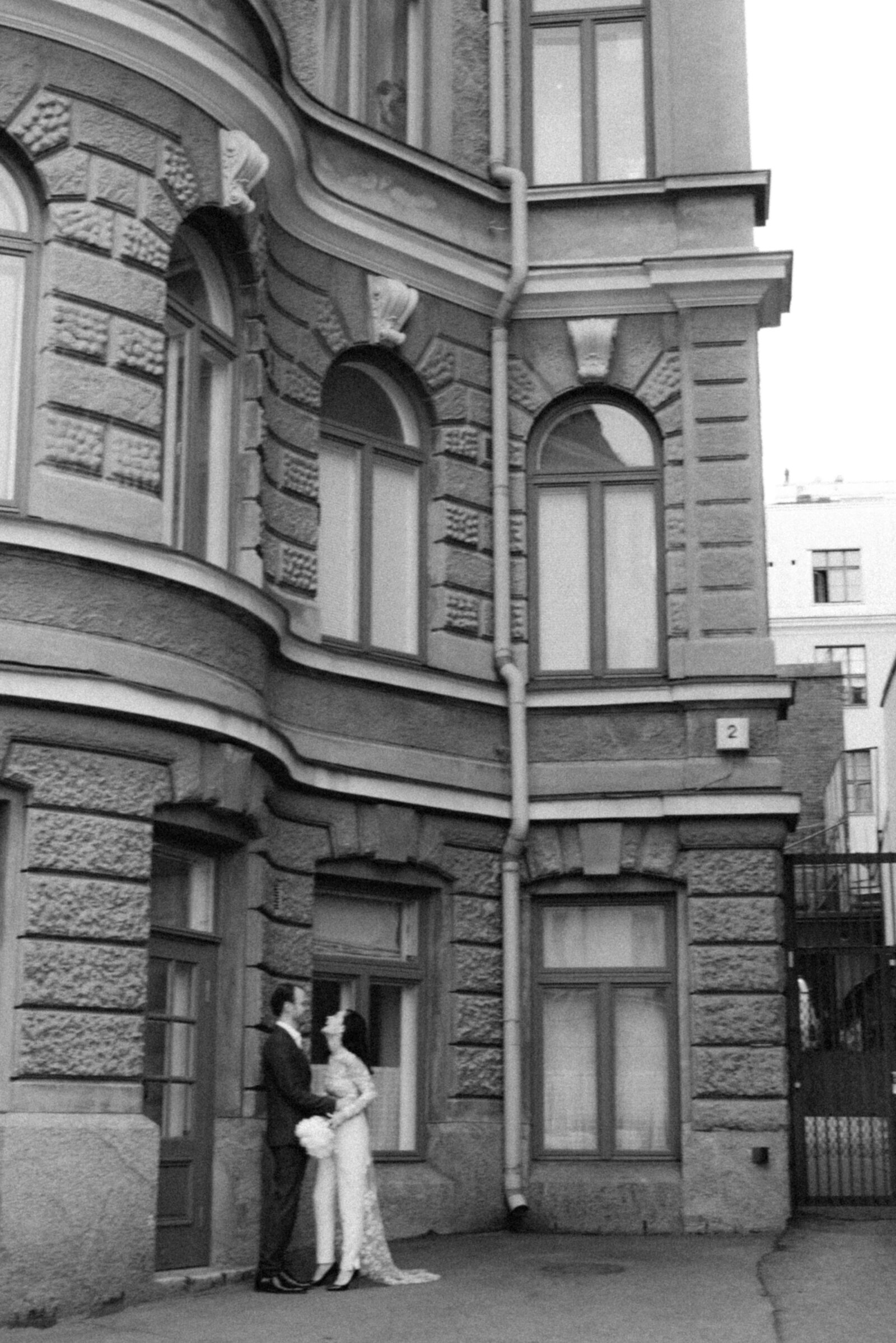 Laughing wedding couple standing in front of a building in Katajanokka Helsinki. Wedding photograph captured by nordic elopement photographer Hannika Gabrielsson.
