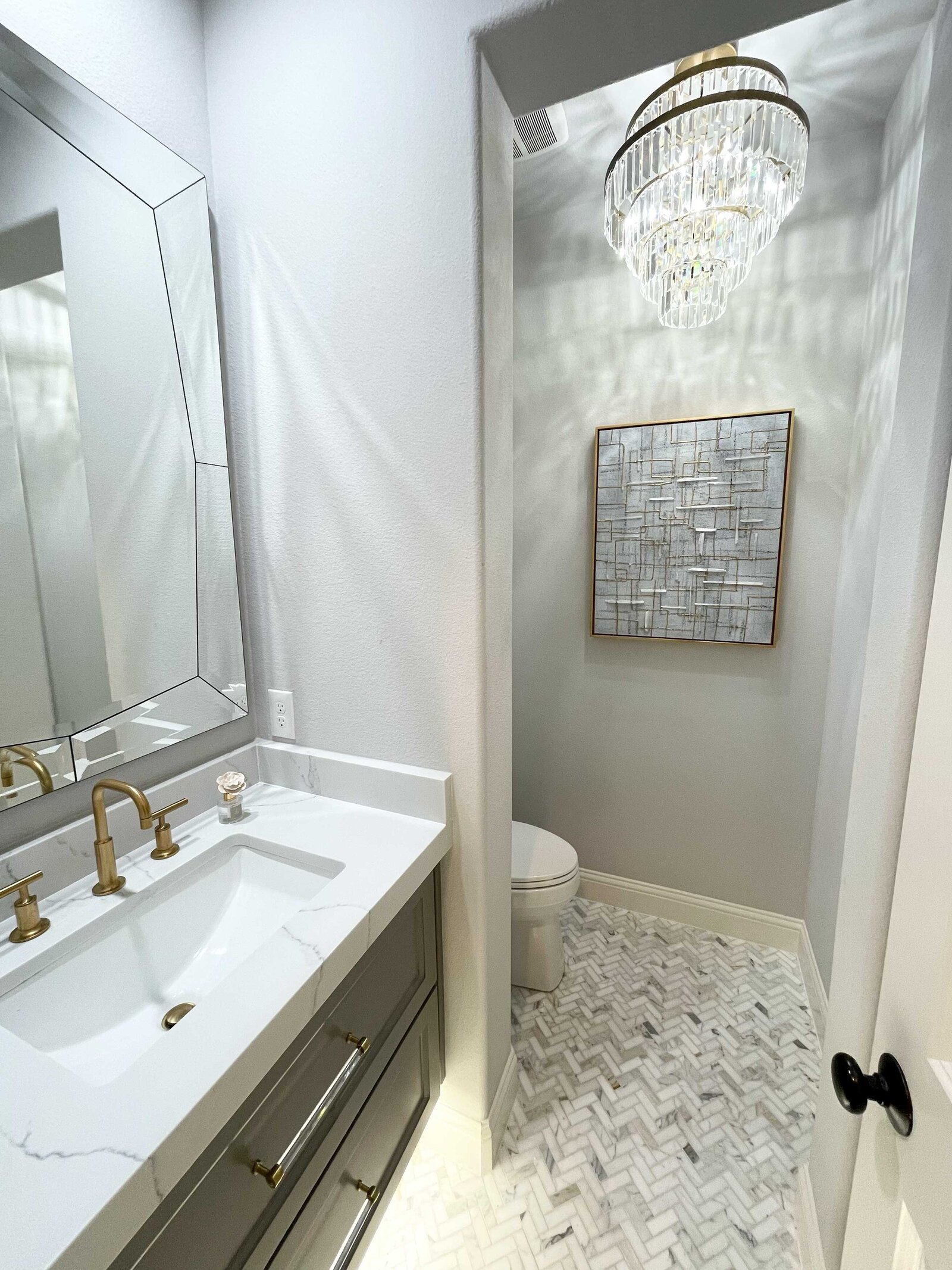 Luxury interior design and renovation in Frisco, featuring elegant materials, a large ceiling lamp, and grey artwork, adding sophistication to the bathroom.