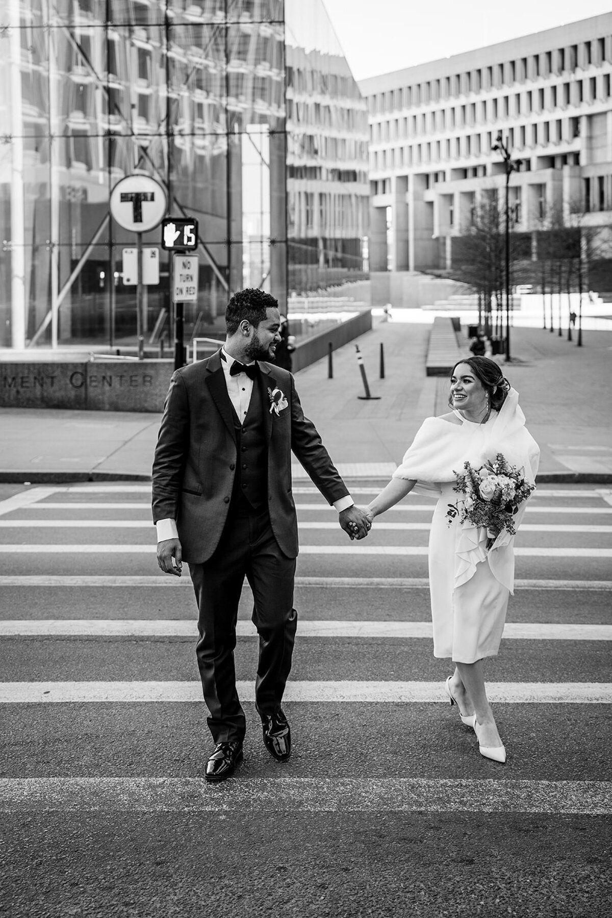 black and white portrait of a bride and groom crossing a city street in boston