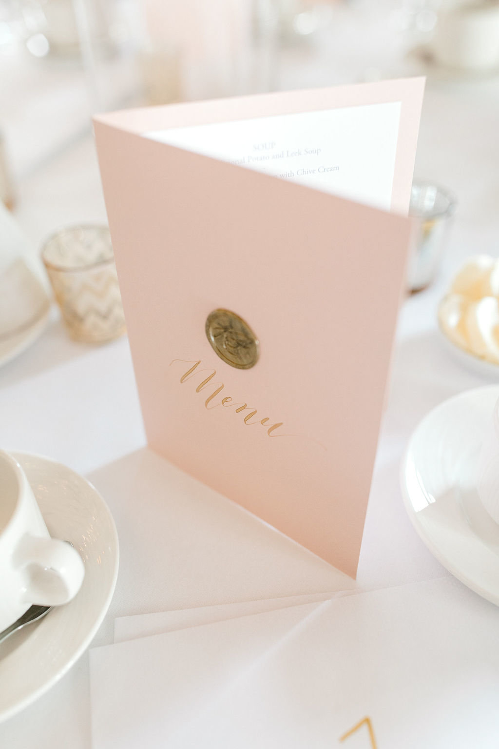 Wedding menu with gold wax seal and blush booklet
