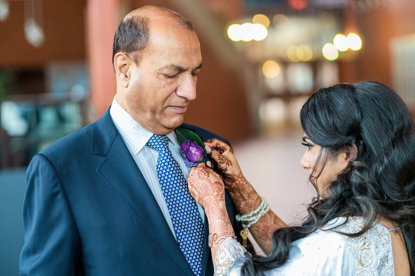 Bride pinning corsage on  father inlaws jacket