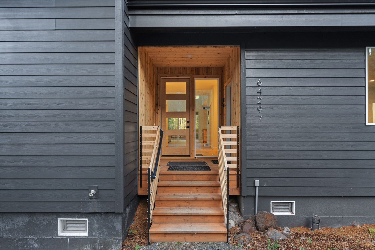 Wooden front entryway with stairs leading to a glass door