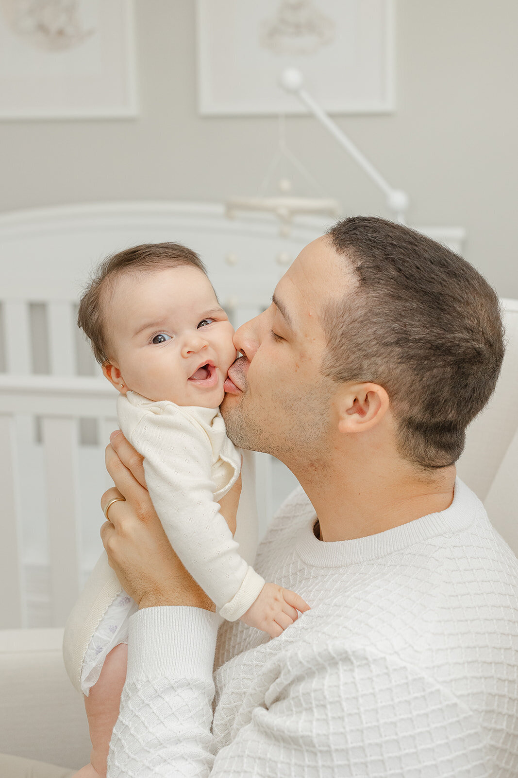 dad and mom kiss baby in Vienna, Virginia