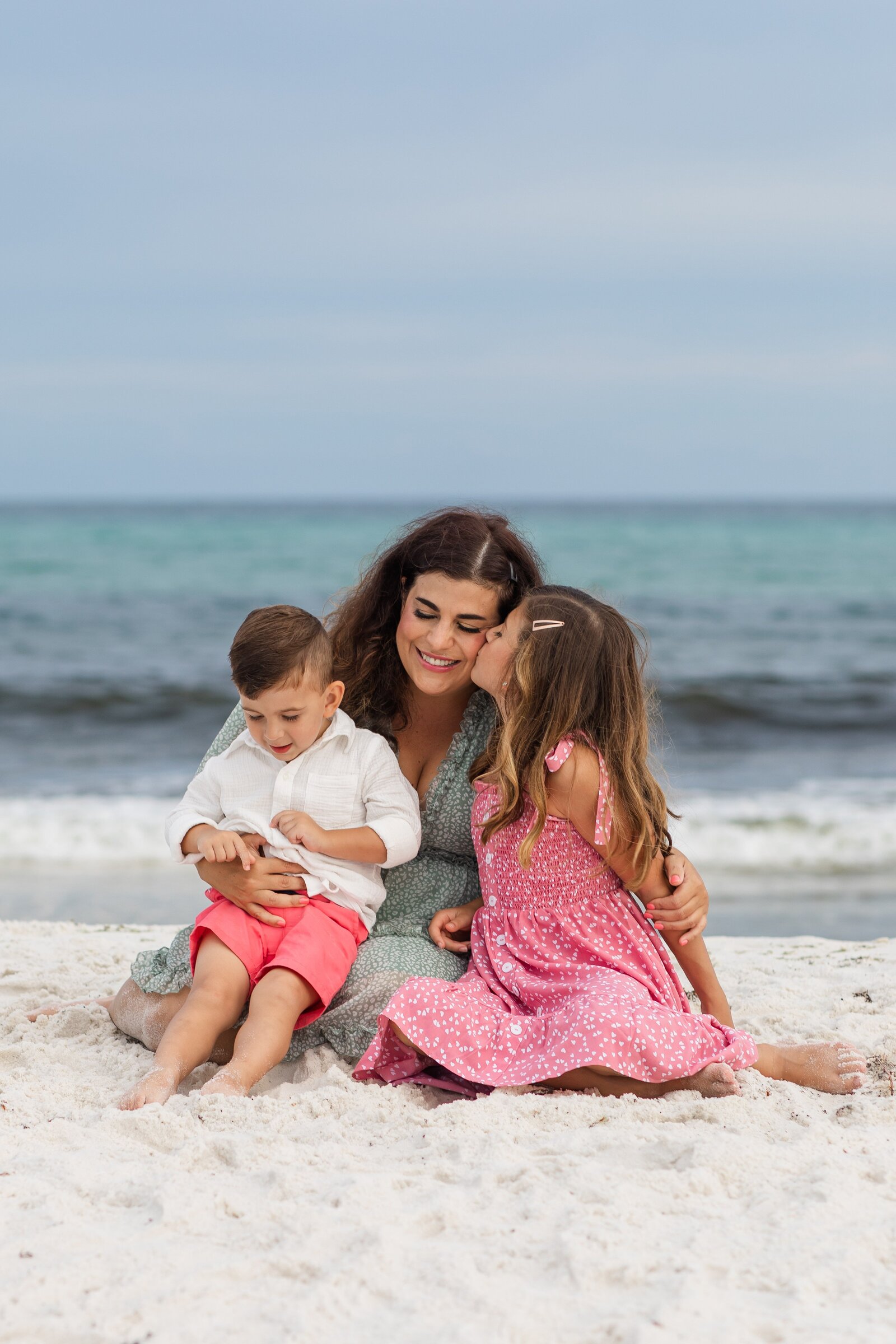 Pensacola Beach family vacation photo session. Kids sitting with mom in the sand.