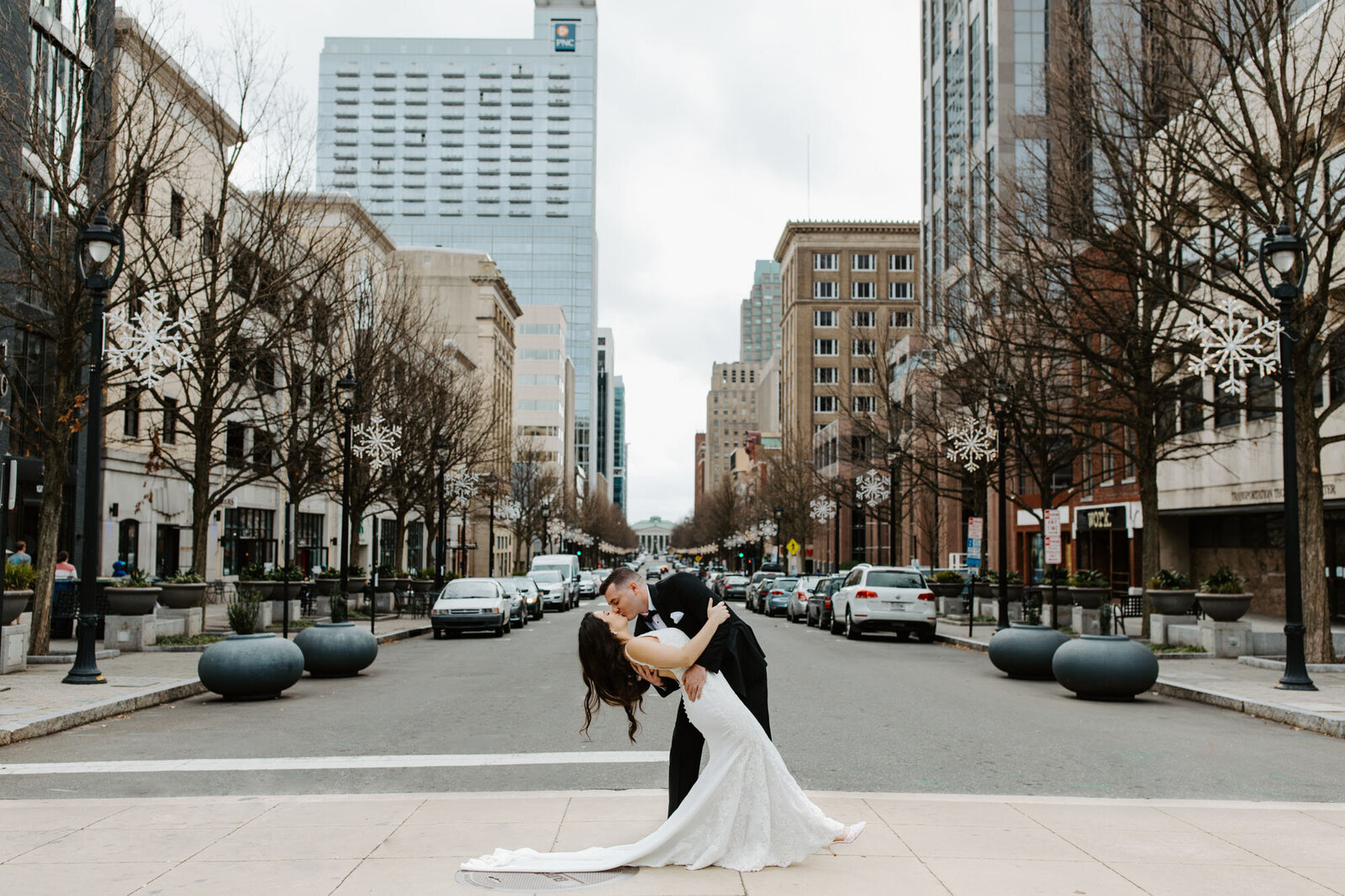 Groom dipping bride in city of North Carolina destination wedding