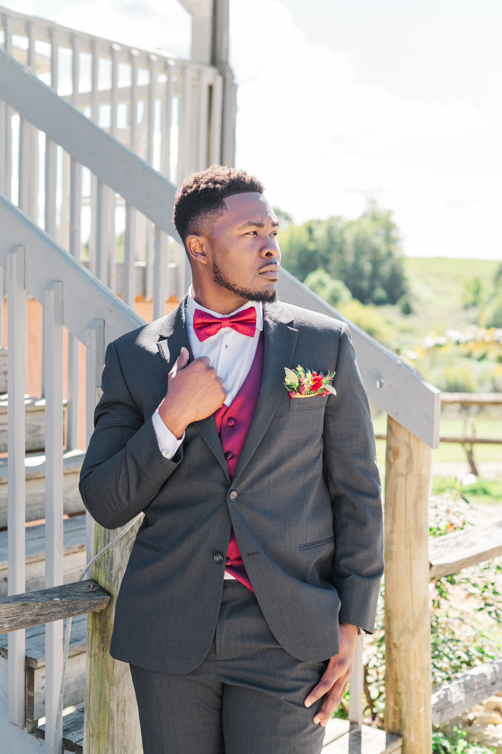 Groom posing for solo portraits in a vineyard