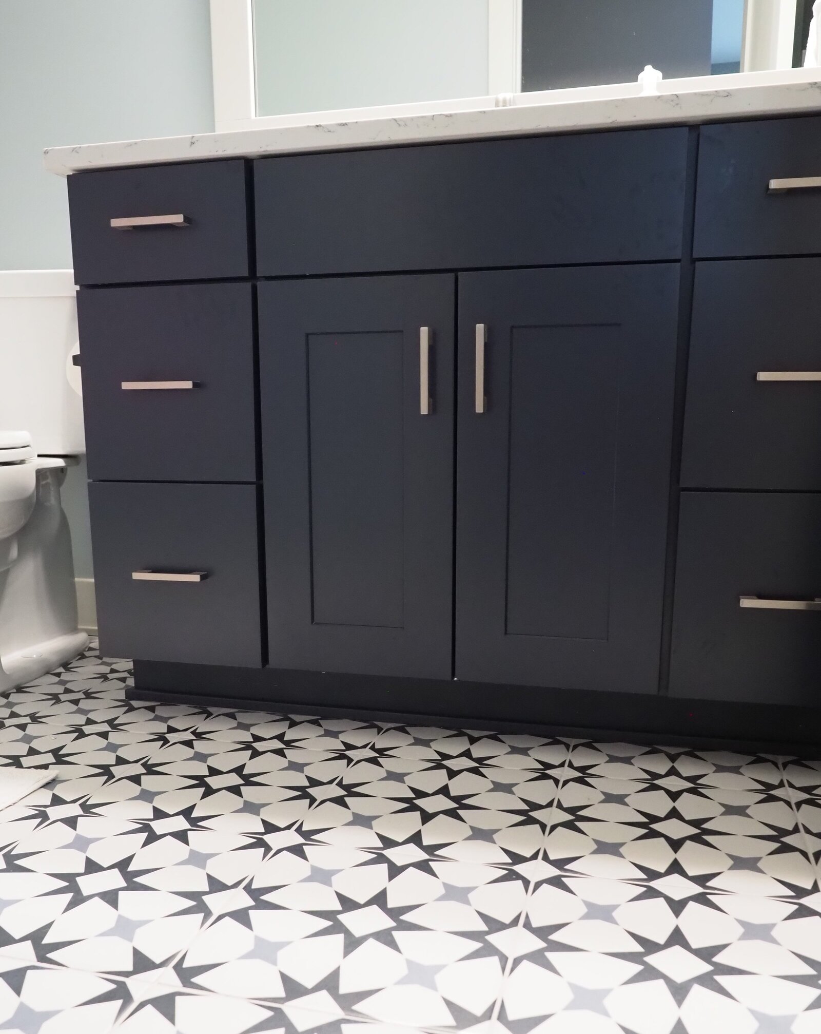 Navy blue vanity with patterned tile florring.